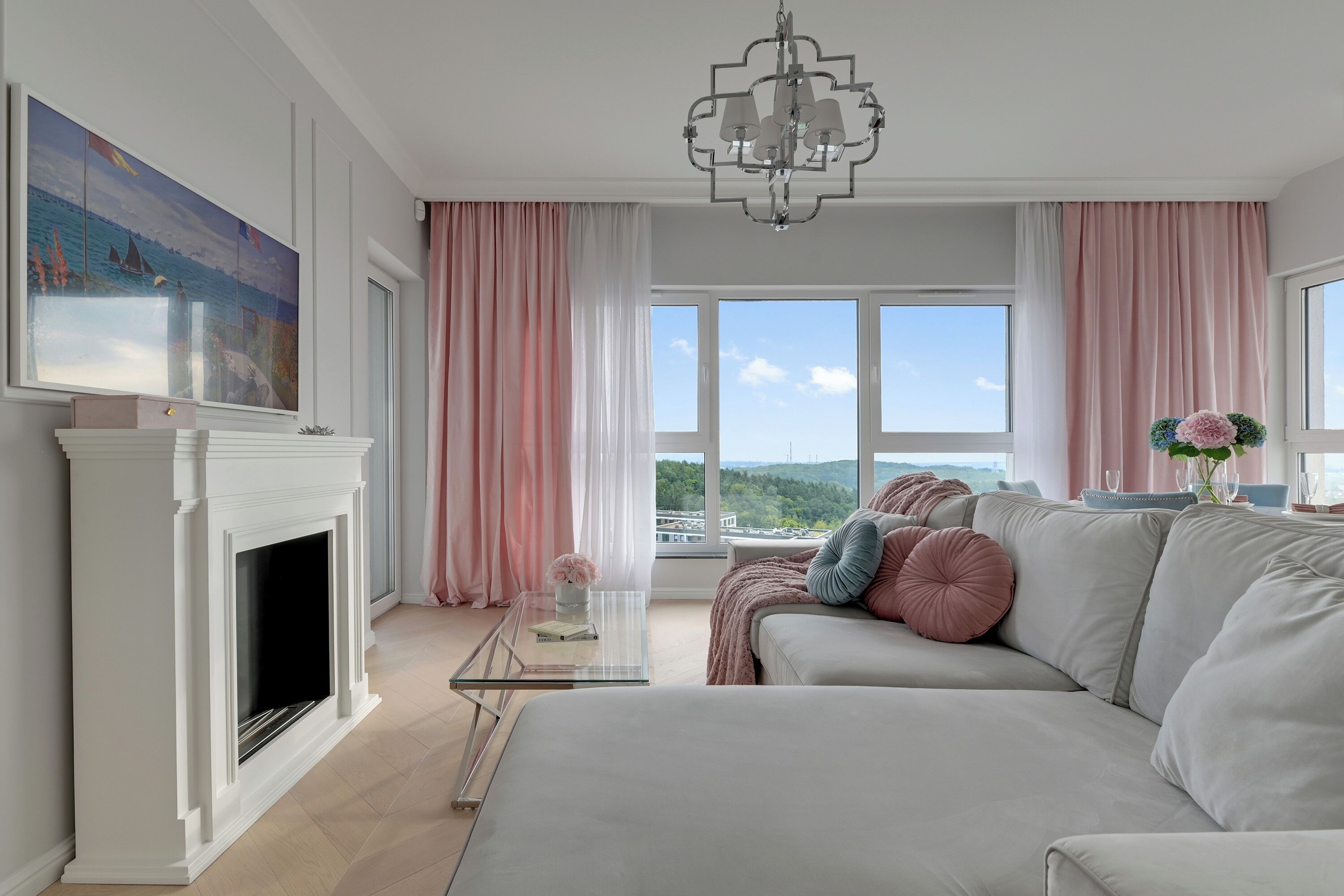 Ein modernes Wohnzimmer mit Kamin, großen Fenstern und Blick auf die Landschaft.