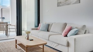 A modern living room with a sofa, a coffee table, and a painting on the wall.