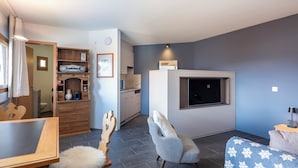 Een moderne woonkamer met een eethoek, keuken en badkamer.