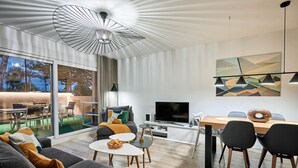 Un salon moderne comprenant un canapé, une table basse, un téléviseur et un coin repas.