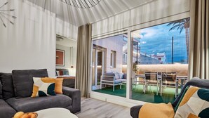 A modern living room with a sofa, a coffee table, and a dining area with a table and chairs. - Conquistador C (El Campello)