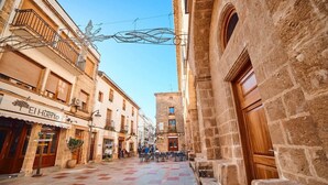 A street with buildings, a café named 'El Huerto', and outdoor seating. - Taylor Apartment (Xàbia)