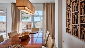 Uma área de refeições com mesa de madeira, cadeiras e um lustre.