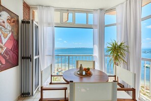 A room with a view of the sea, a table with fruit, and a plant. - San Pedro de Pinatar (San Pedro del Pinatar)