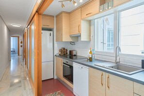 A modern kitchen with wooden cabinets, a stainless steel sink, and a window providing natural light.