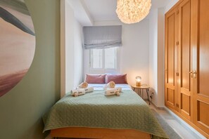 A bedroom with a bed, pillows, a bedside lamp, and a wardrobe.