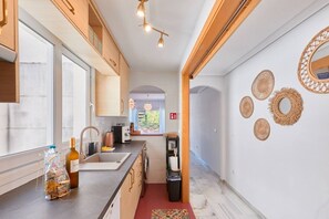 Eine moderne Küche mit einem großen Fenster, einer Spüle und einer Arbeitsplatte mit verschiedenen Gegenständen.