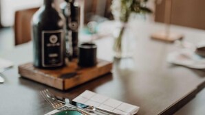 A dining table with a bottle, a cup, and a plate of food. - Mercure Hotel Hamburg City (Hamburg)