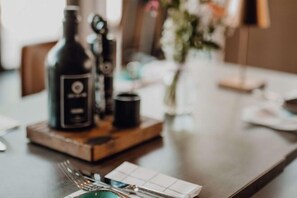 Una mesa de comedor con una botella, una taza y un plato de comida.