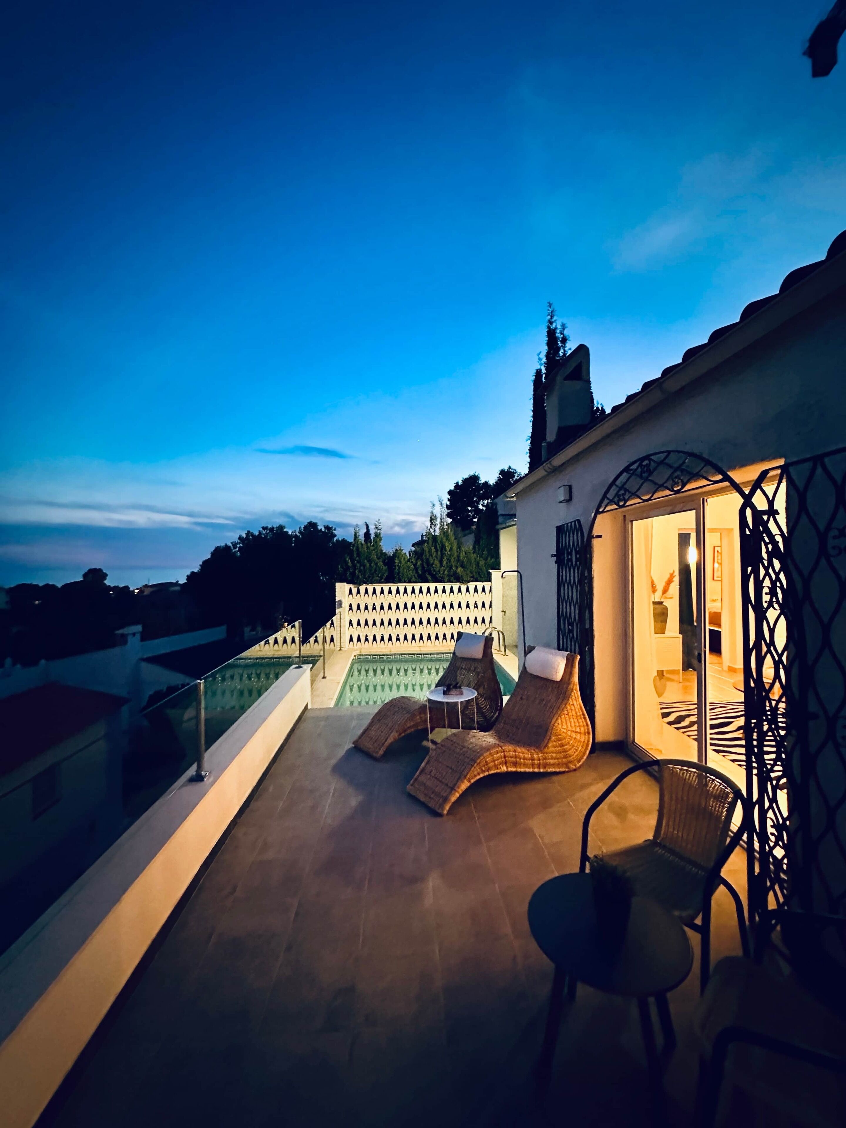 Une terrasse sur le toit avec une piscine, des chaises longues et un espace salon abrité.