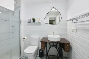 A bathroom with a toilet, sink, and shower.