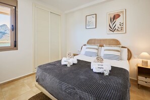 Une chambre d’hôtel avec un lit, une table de chevet, une lampe et des œuvres d’art accrochées au mur.