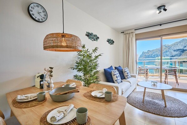 Un espace repas comprenant une table ronde, des chaises et un luminaire suspendu.