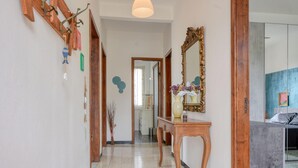 A hallway with a wooden bench, a mirror, and a vase with flowers. - Lovely home in Chiavari with WiFi (Chiavari)