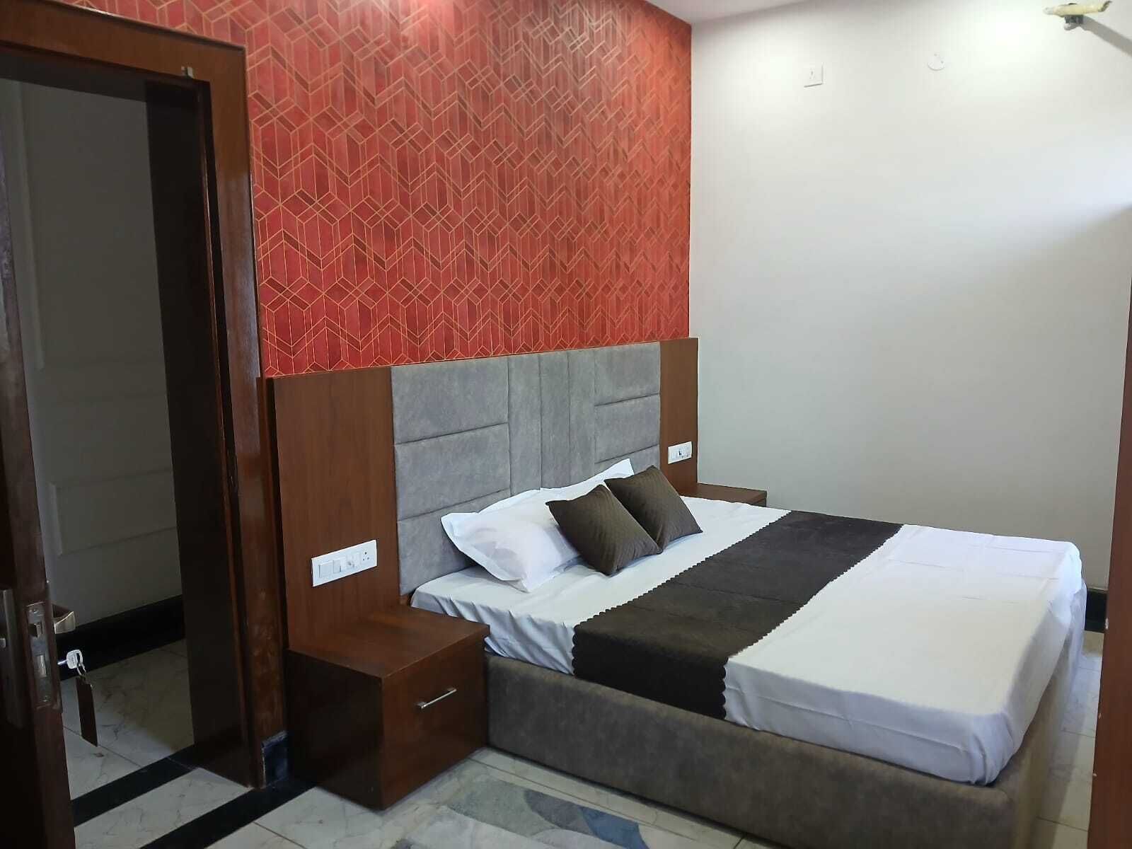 Una habitación de hotel con cama, mesitas de noche y una puerta.