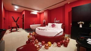 A red-themed bedroom with a bed, a vanity, a chair, and a desk. - Hotel Trung Mai-Tân Bình (Ho Chi Minh City)