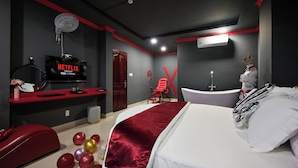 A modern hotel room with a large bed, a red accent wall, a TV displaying 'Netflix', and a red chair. - Hotel Trung Mai-Tân Bình (Ho Chi Minh City)