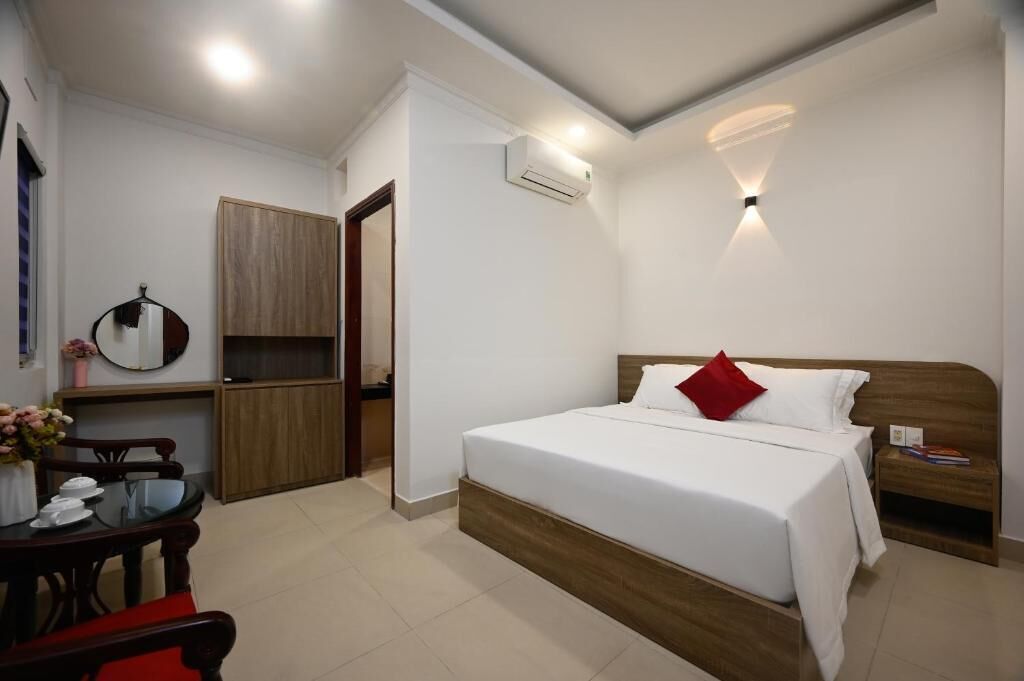 Ein Hotelzimmer mit Bett, Nachttisch und einer kleinen Schreibtischzeile.