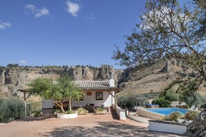 Une villa dotée d’un patio, d’un espace salon extérieur, d’une piscine et offrant une vue sur une falaise.