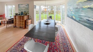 A dining area with a large table, chairs, a rug, and artwork on the walls. - Beautiful home in Esbjerg V with WiFi (Esbjerg V)