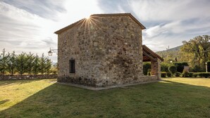 A stone building with a sloped roof, a small window, and a lamp post. - La Casina Cottage by Geco Vacation Rentals (Bucine)