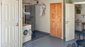 A laundry room with a washing machine, dryer, and a wooden door.
