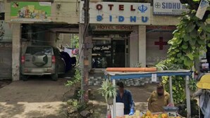 A building with a sign for 'Hotel Sidhu' and a fruit cart outside. - HOTEL SIDHU  (Jamshedpur)