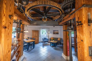 A rustic interior with a dining area, a sofa, and a ceiling fan. - Holiday Home 'Windmill Betty by the North Sea' with Private Terrace, Private Garden and Wi-Fi (Cuxhaven)