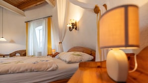A bedroom with two beds, a bedside table, a lamp, and a wall-mounted light fixture. - Holiday Home 'Windmill Betty by the North Sea' with Private Terrace, Private Garden and Wi-Fi (Cuxhaven)