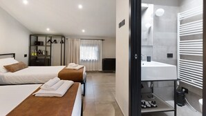 A hotel room with two beds, a bathroom with a modern sink and towel rack, and a mirror. - Room 'Agr Casa Pezzo Triple Room 3' with Shared Pool, Wi-Fi and Air Conditioning (Castelnuovo del Garda)