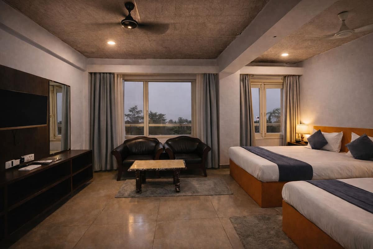A hotel room with a bed, a sofa, a TV, and a balcony.