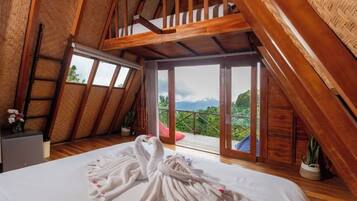Un dormitorio con cama, techo de madera y balcón con vistas.