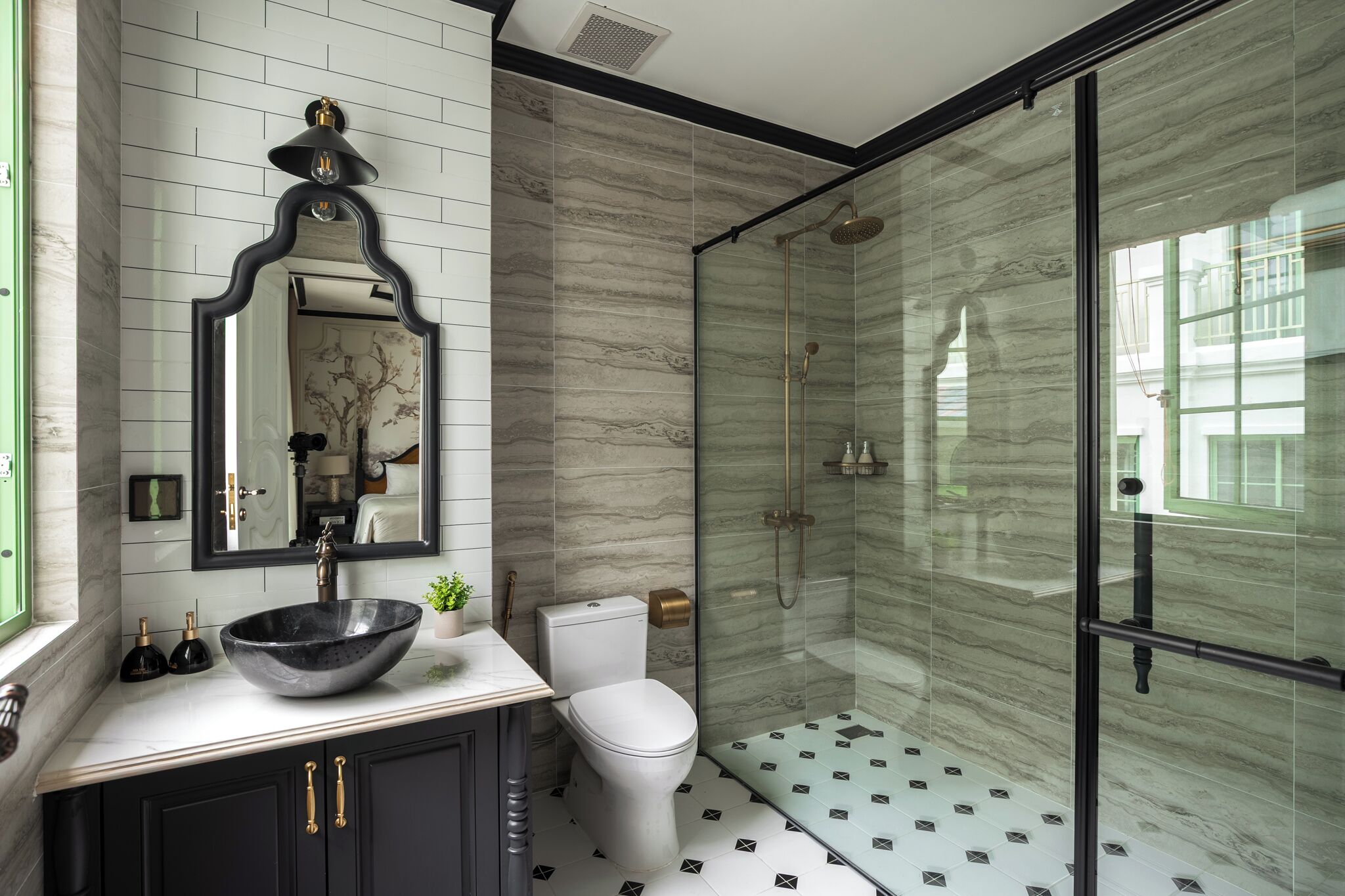 Un baño con un espejo grande, un lavabo sobre encimera, inodoro y ducha con mampara de vidrio.