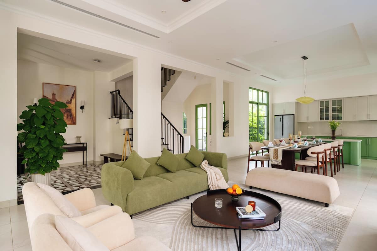 A spacious living area with a sofa, coffee table, and a dining table set for a meal.