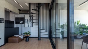 Et moderne interiør med trappe, sofa og sofabord.