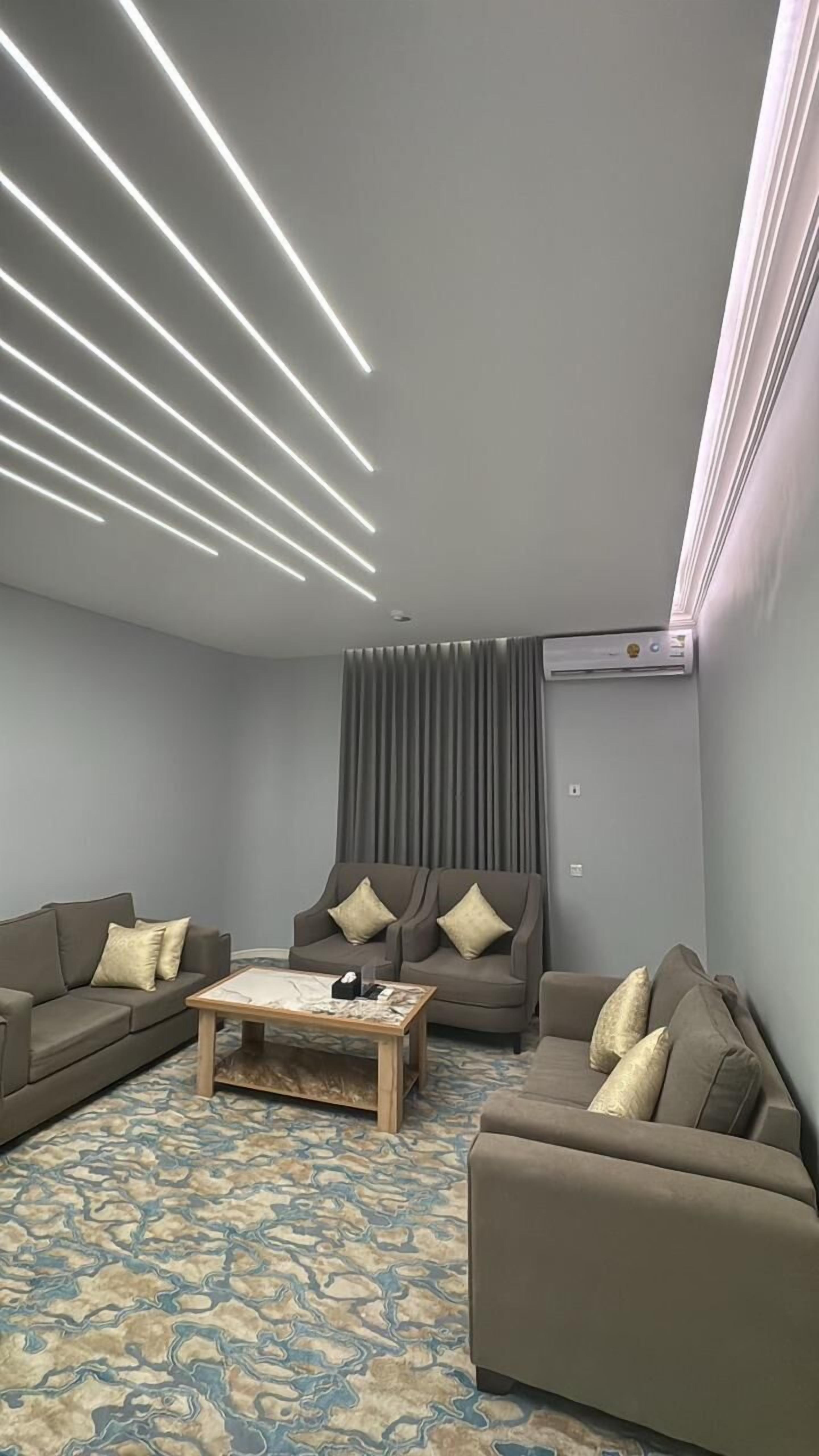 A modern living room with a sectional sofa, a coffee table, and a patterned rug.