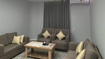 A modern living room with a sectional sofa, a coffee table, and a patterned rug.