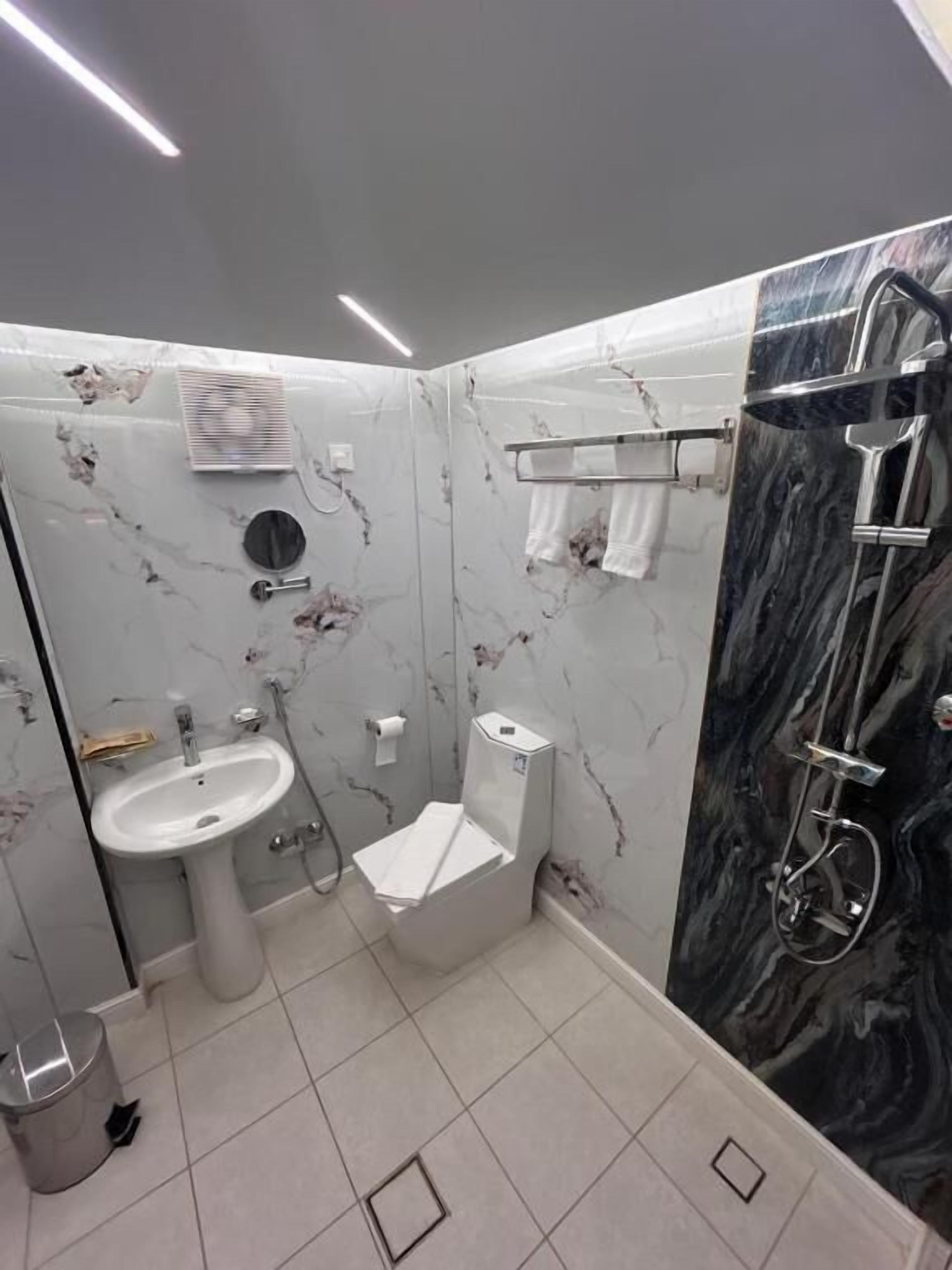 A bathroom with a sink, toilet, and shower.