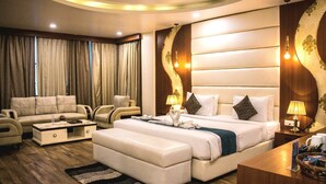 Una habitación de hotel moderna con una cama grande, un sofá, una mesita de café y un escritorio.