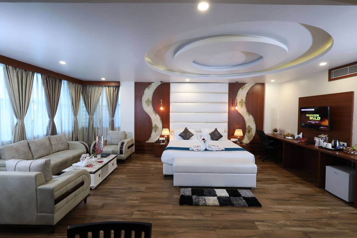 Une chambre d’hôtel moderne équipée d’un canapé, d’un lit, d’un bureau et d’une télévision.