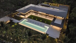 A modern house with a large swimming pool, surrounded by palm trees. - Saba Estate Luxury Villa Bali (Bali)