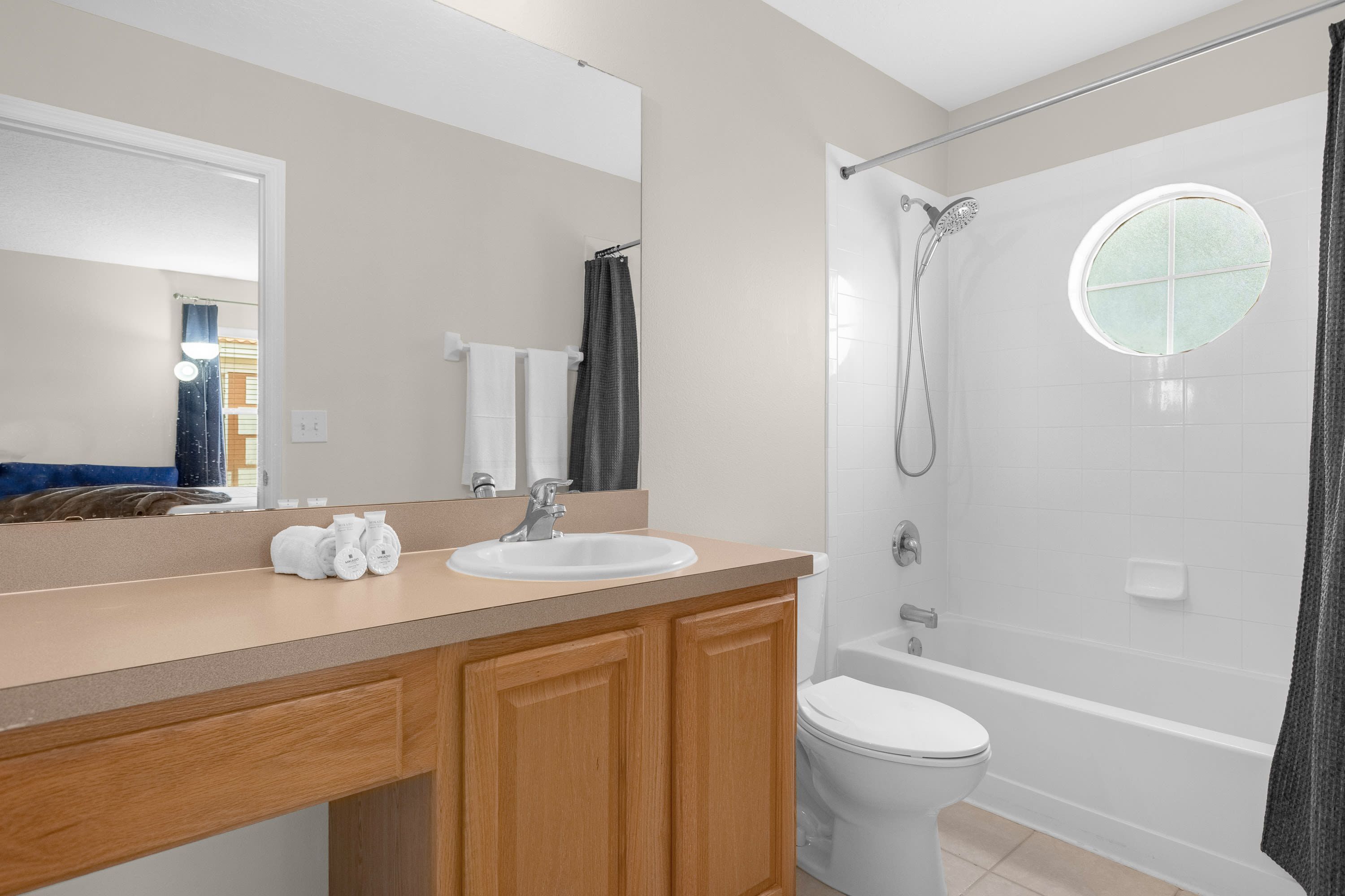 Une salle de bain moderne avec un lavabo, un miroir et des toilettes.