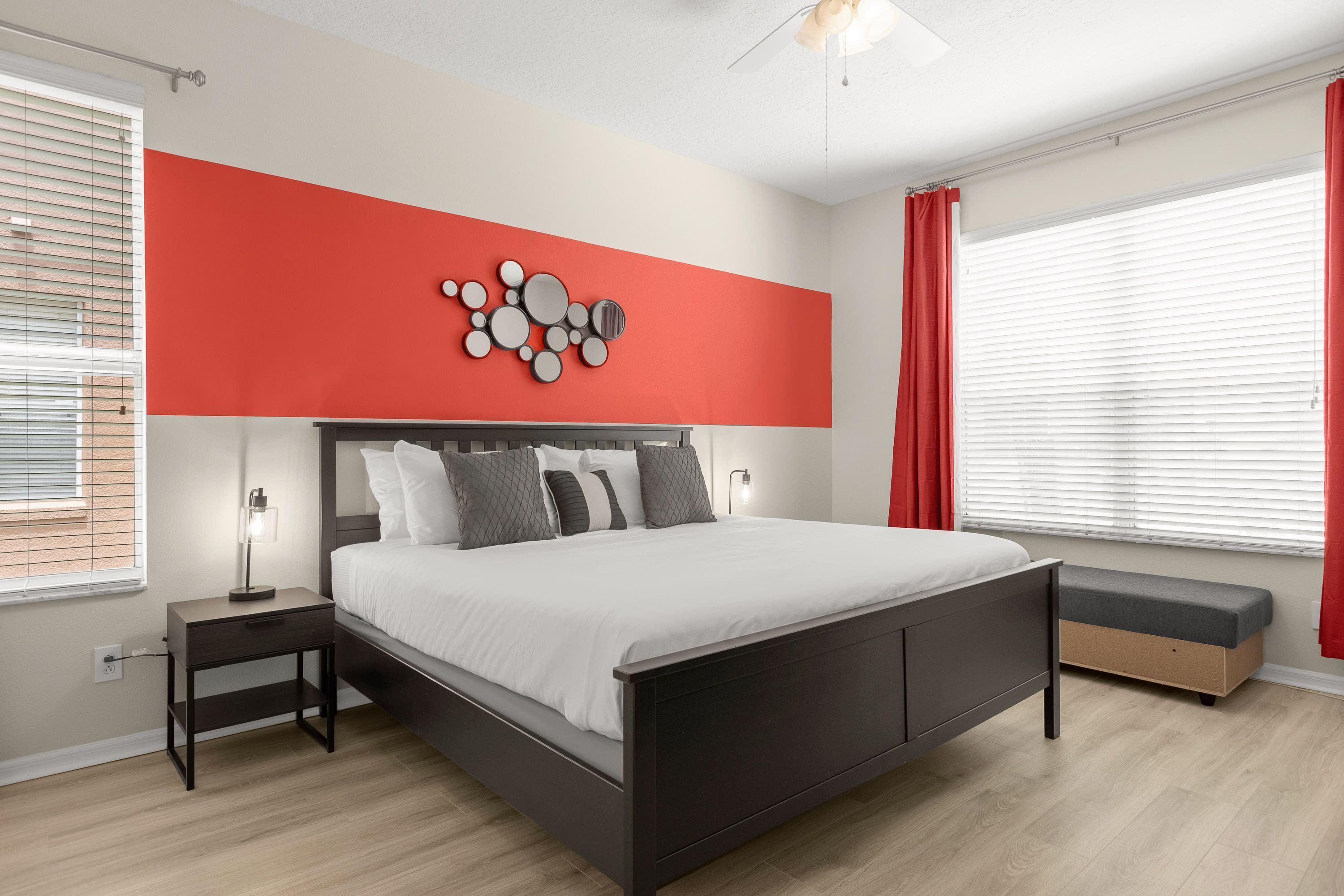 A modern bedroom with a bed, bedside tables, a bench, and a wall art piece.