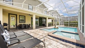 A covered outdoor area with a pool, lounge chairs, and a barbecue setup. - Upstay Championsgate 9BR Villa With Pool Cinema (Davenport)