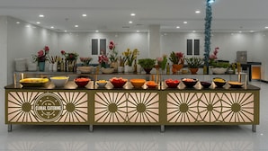 A buffet setup with various food bowls and decorative plants. - Moro Alalameyah Hotel Makkah (Makkah)