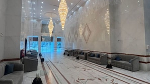 A spacious lobby with marble floors, multiple seating areas, and decorative chandeliers. - Moro Alalameyah Hotel Makkah (Makkah)