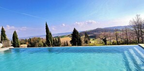 Una piscina con una vista despejada de un paisaje montañoso al fondo.