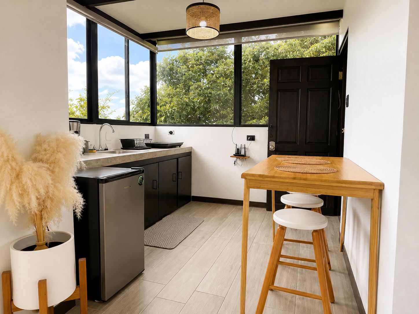 Eine moderne Küche mit einem großen Fenster, einem Holztisch und einem Barhocker.