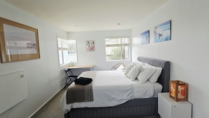 A bedroom with a bed, a desk, and two windows. - LILYPAD 4-bedroom Urban Retreat Auckland (Auckland)