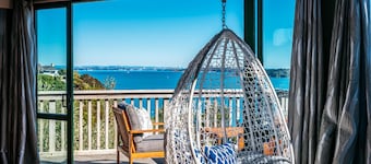 Spinnaker Watch - A relaxed coastal retreat with breathtaking views to Auckland City. Spinnaker Watch offers spacious living, linen furnishings, sunny decks, and a short walk to the beach the perfect Waiheke escape for couples or small groups.